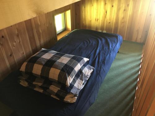 a bed in a room with a pillow on it at 【1日1組限定】長野県・安曇野の一軒家貸切宿 「うまや UMAYA」 in Matsukawa