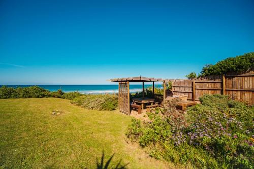 a backyard with a picnic table and a gazebo at Seester Strandhuis in Jeffreys Bay