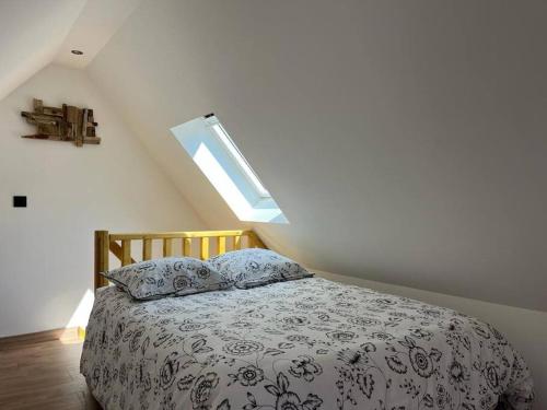 um quarto com uma cama com uma almofada e uma janela em La Masure - Jacuzzi privatif - La mer à deux pas em Cayeux-sur-Mer