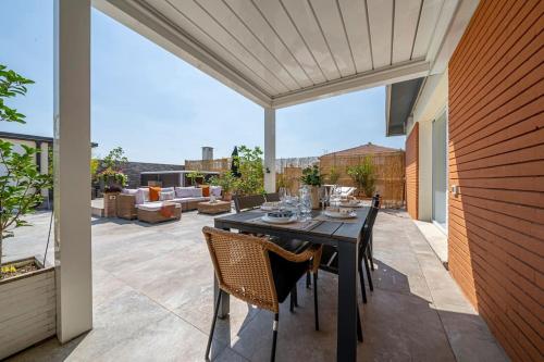 a patio with a table and chairs on a patio at [Via Indipendenza] – Attico di lusso con Piscina in Bologna