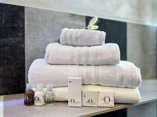 a stack of towels on a counter with bottles of soap at [Via Indipendenza] – Attico di lusso con Piscina in Bologna
