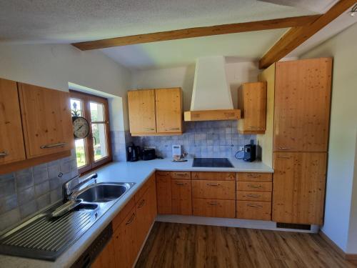 a kitchen with wooden cabinets and a sink and a window at Ferienwohnung Gschwendt in Gföhl