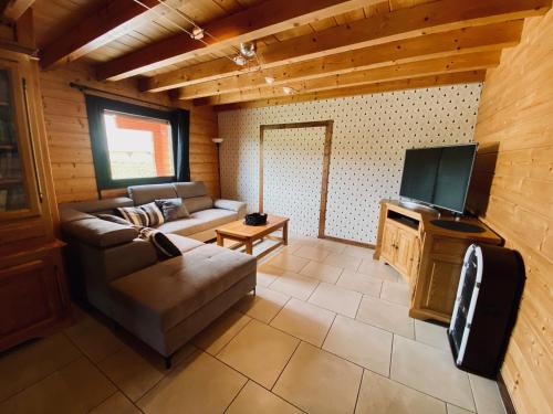 ein Wohnzimmer mit einem Sofa und einem Flachbild-TV in der Unterkunft Chalet indépendant 2000m2 de terrain 3 chambres 