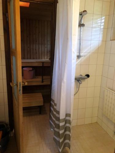 ein Bad mit Dusche und Duschvorhang in der Unterkunft Apartment Retkeilijäntie 18, Kuopio in Kuopio