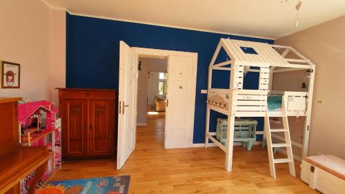 Habitación con pared azul y litera en Apartament Berg en Szczawno-Zdrój