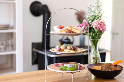 a three tiered tray with plates of food on a table at Hofgut Mollberg in Wiefelstede