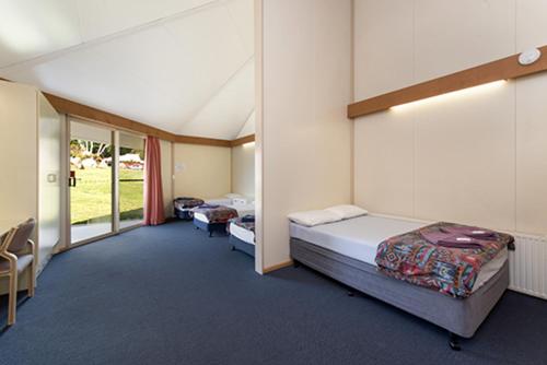 a large room with two beds and a window at The Station Hotel in Jindabyne