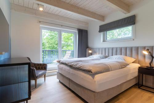 ein Schlafzimmer mit einem großen Bett und einem Fenster in der Unterkunft Lodge54 in Sankt Peter-Ording