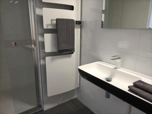 biała łazienka z umywalką i prysznicem w obiekcie Villa Buffon w mieście Angers