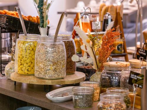 a counter with jars of seeds and other food items at Mercure Clermont Ferrand centre Jaude in Clermont-Ferrand