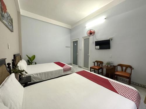 um quarto de hotel com duas camas e uma televisão de ecrã plano em OYO 1187 Suoi Da Motel em Da Nang