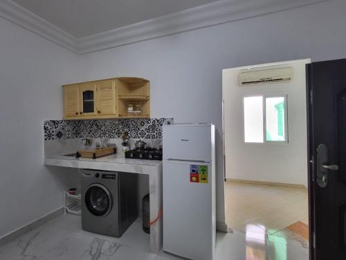 uma cozinha com um frigorífico e uma máquina de lavar roupa em Appartement Tanger 3 em Tânger