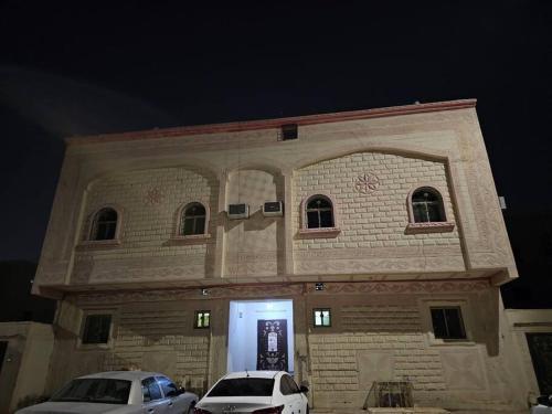un edificio con dos coches estacionados frente a él en شقة مفروشة في المدينة المنورة- رانونا1, en ‘Urwah
