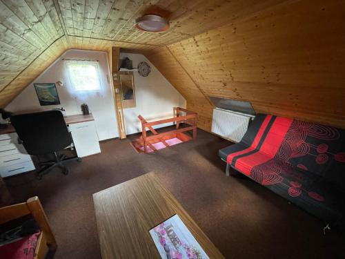 Habitación con cama y escritorio en una cabaña en Ubytko v Průhonu en Velhartice