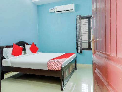sypialnia z łóżkiem i czerwonymi drzwiami w obiekcie OYO Flagship Sea Coastal Inn w mieście Kakinada