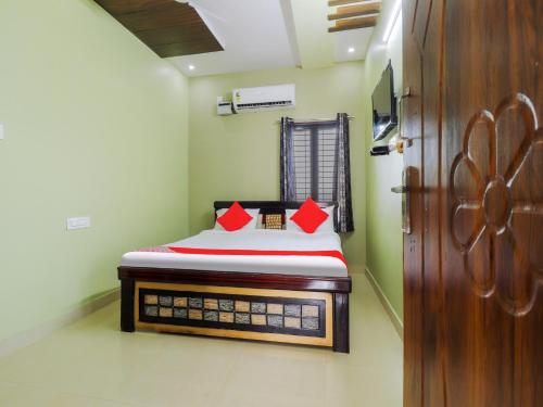 małą sypialnię z łóżkiem z czerwonymi poduszkami w obiekcie OYO Flagship Sea Coastal Inn w mieście Kakinada