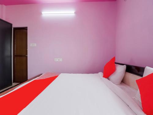 a bedroom with a red and white bed and a television at Hotel O Sea Coastal Inn in Kākināda