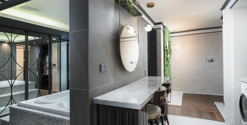 a bathroom with a sink and a bath tub at Utop Boutique Hotel&Residence in Gwangju