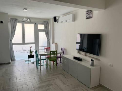 a living room with a television and a table and chairs at Holiday House in Ancona