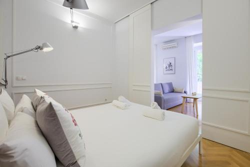 een witte slaapkamer met een bed en een bank bij Charming Lavapies Center in Madrid