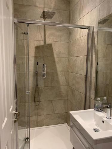 een badkamer met een douche en een wastafel bij Wonderful 3 Bed Flat with Private Garden in Wimbledon - 1 The Queens in Londen