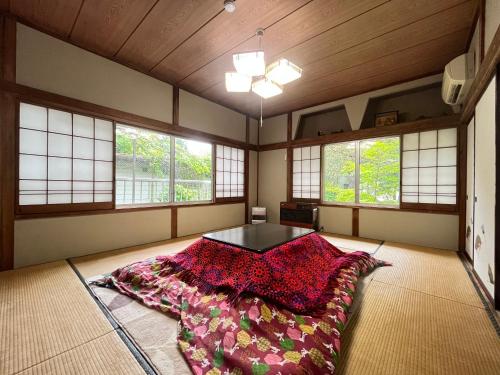 a bedroom with a bed in a room with windows at Narusawaso in Narusawa
