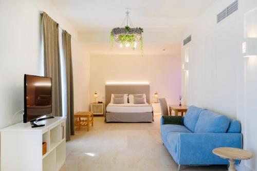 a living room with a blue couch and a bed at Regiohotel Manfredi in Manfredonia