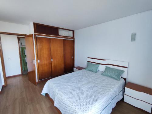 1 dormitorio con 1 cama y armario de madera en Machico Terrace, en Machico