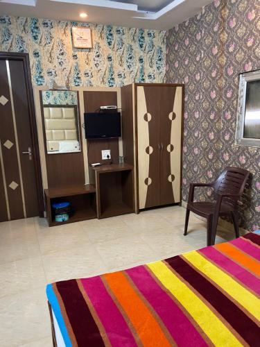 1 dormitorio con cama, silla y escritorio en HOTEL ROBIN, en Amritsar