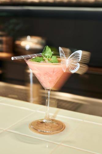 a pink drink with a butterfly on a table at Cocoon Salzburg in Salzburg