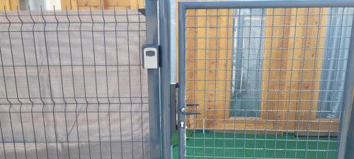 a metal door with a gate in front of a window at Chalet piscine montech in Montech