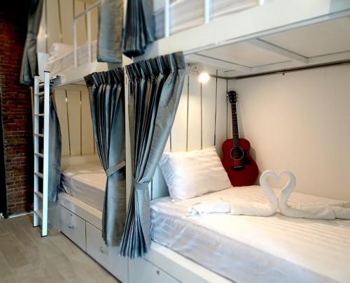 a room with two bunk beds and a guitar at What's Up Chiang Mai in Chiang Mai