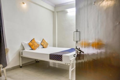 Habitación blanca con cama con almohadas amarillas en OYO Hotel Rajwaada Palace en Bhopal