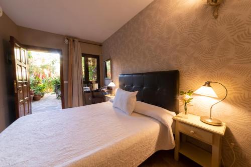 a bedroom with a large white bed and a lamp at La Asomada del Gato in Las Lagunas