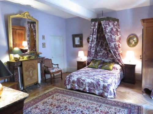 um quarto com uma cama de dossel em La Maison de la Tour em Semur-en-Auxois