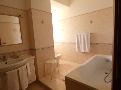 a bathroom with a tub and a sink and a toilet at Villa Magnolia B&B in Taormina
