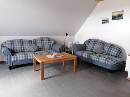 a living room with two couches and a coffee table at Ferienwohnung Mangelsen in Gelting