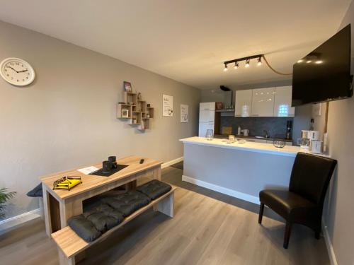 Zimmer mit einem Tisch und einem Stuhl sowie einer Küche in der Unterkunft Ferienwohnung Riffgat in Emden
