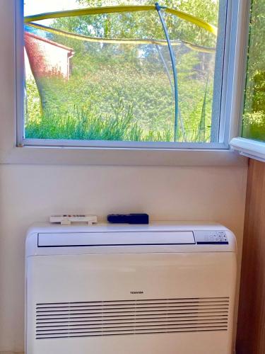 a window above a heater in front of a window at Appartement neuf et au calme proche Avignon in Althen-des-Paluds