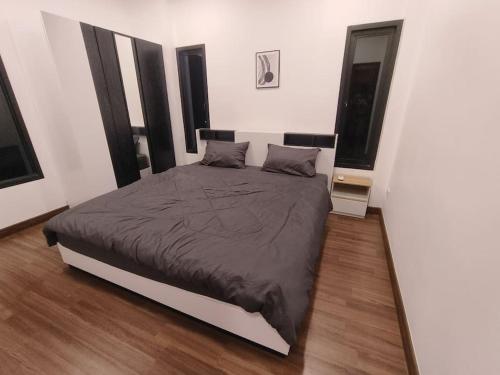 um quarto com uma cama grande num quarto com duas janelas em KS villa em San Sai
