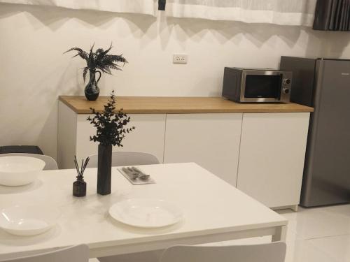 uma cozinha com uma mesa branca e um micro-ondas em KS villa em San Sai