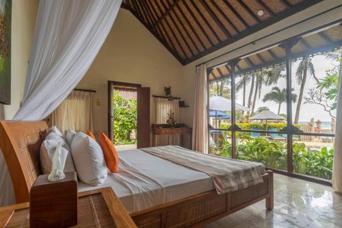 a bedroom with a bed with a view of the ocean at Nusa Indah Candidasa in Candidasa