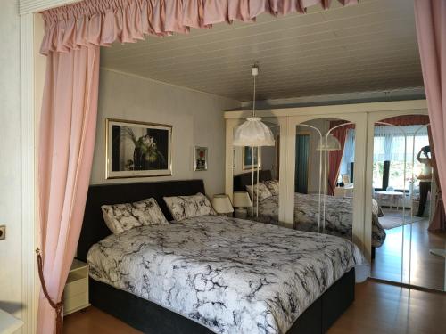 1 dormitorio con 1 cama grande y cortinas rosas en Sunny Hill, en Oberthal