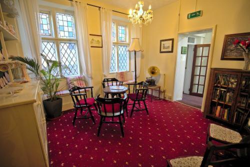 a room with a table and chairs on a red carpet at Lewinsdale Lodge in Weston-super-Mare