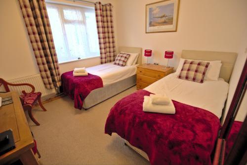 a bedroom with two beds and a window at Lewinsdale Lodge in Weston-super-Mare