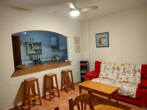 a living room with a couch and a table with stools at la hacienda in Islantilla