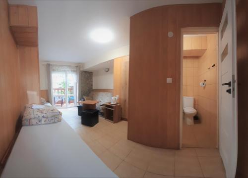 a bedroom with a bed and a bathroom with a toilet at Dom gościnny Moana in Pobierowo