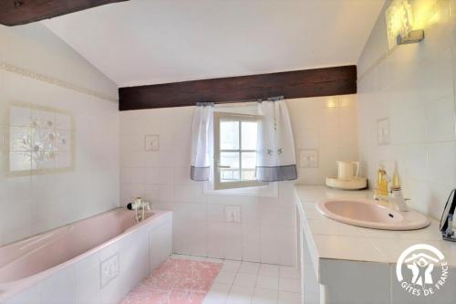 a bathroom with a sink and a tub and a window at Villa Mariella in Arles