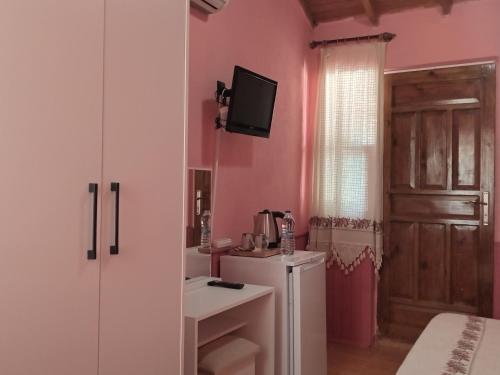 a bathroom with pink walls and a sink and a refrigerator at Akya Adrasan Pansiyon in Adrasan