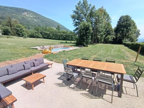 a patio with a wooden table and chairs at Manoir du Colombier in Chavornay